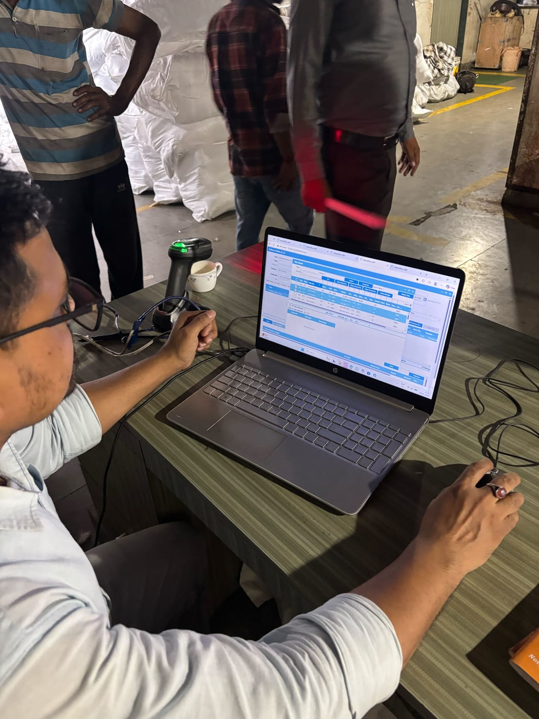 Anubha Fabrics dispatch station with barcode scanner and MobiOffice open on laptop