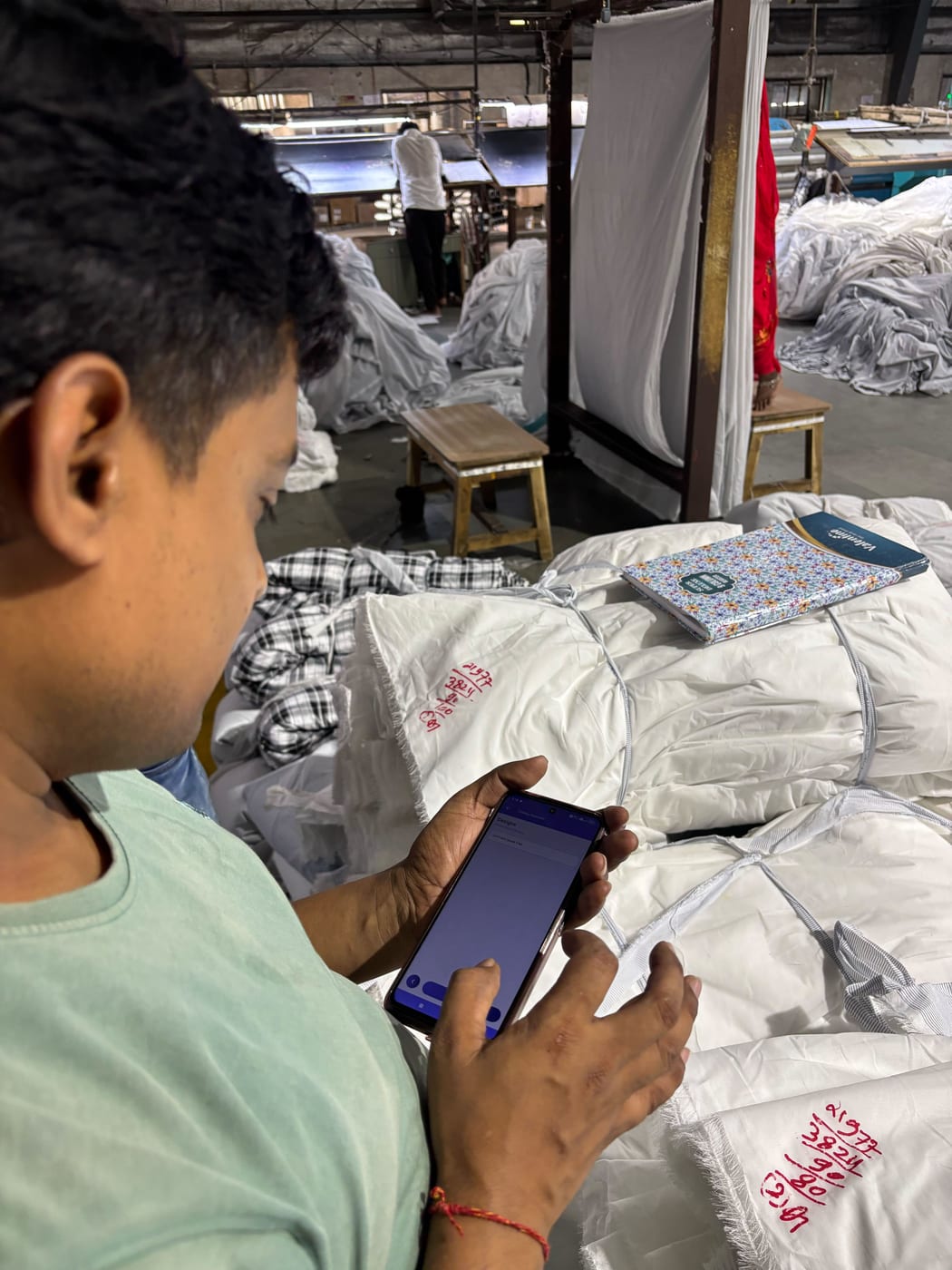 Anubha Fabrics supervisor checking the MobiOffice mobile app on the floor
